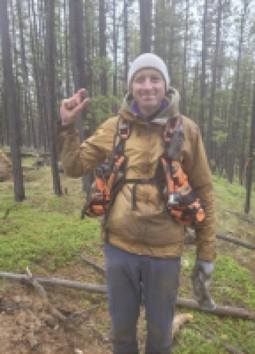 a man holding a point in a forest a man holding a point in a forest